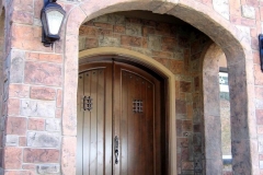 Stone-Edge-Surfaces-decorative-concrete-overlay-hand-carved-stone-entryway-with-border-arch
